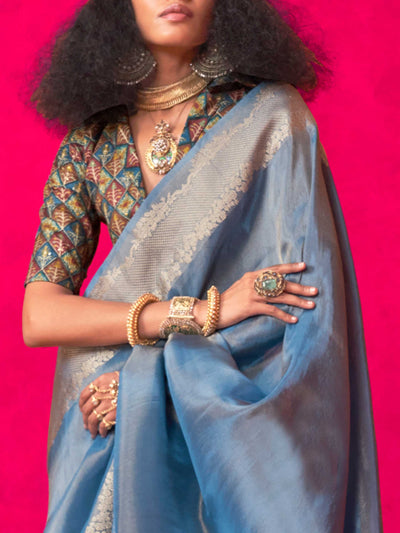 Stone Blue–Silver Zari tissue viscose silk saree with jacquard woven zari work, ideal for weddings, bridesmaids, and elegant evening events. Features tassel border and shimmering finish. Stone Blue–Silver Zari tissue viscose silk saree with jacquard woven zari work, ideal for weddings, bridesmaids, and elegant evening events. Features tassel border and shimmering finish..
