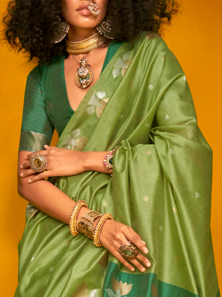 Leaf Green–Teal Green feathersoft tussar silk saree featuring woven lotus motifs and soft pallu, styled for festive rituals with a breathable finish. Leaf Green–Teal Green feathersoft tussar silk saree featuring woven lotus motifs and soft pallu, styled for festive rituals with a breathable finish..