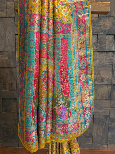 Colorful traditional fabric with intricate patterns on a wooden surface.