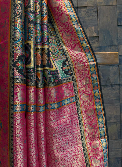 Colorful patterned saree draped over a wooden surface with a dark tiled background
