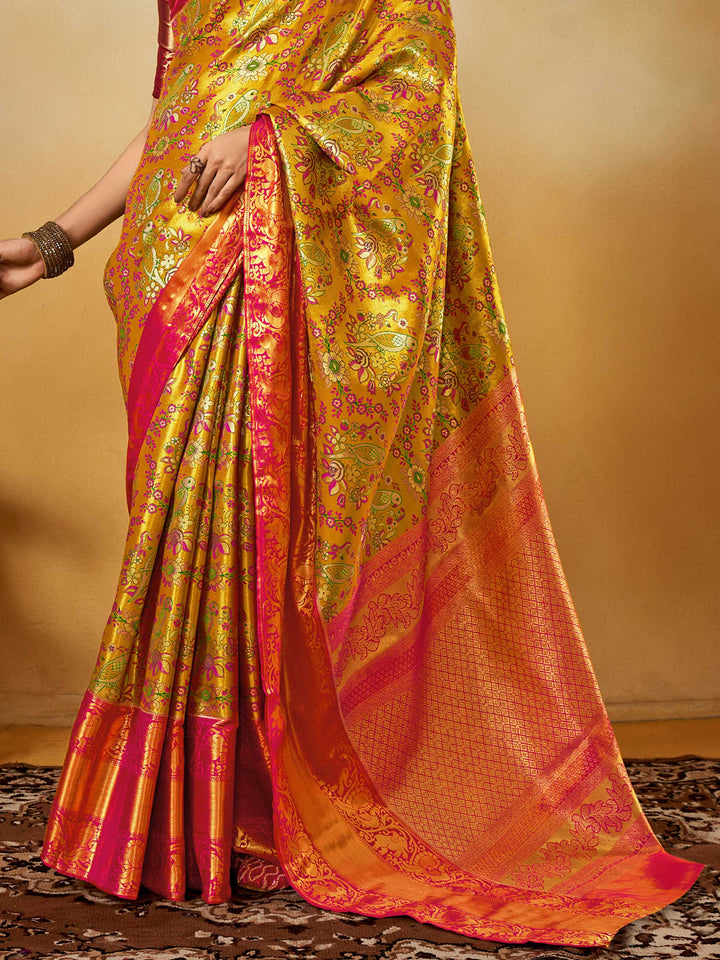Yellow–Pink Banarasi satin silk saree with zari work and woven parrot motifs, styled for traditional Indian wedding rituals with luxury finish. Yellow–Pink Banarasi satin silk saree with zari work and woven parrot motifs, styled for traditional Indian wedding rituals with luxury finish..