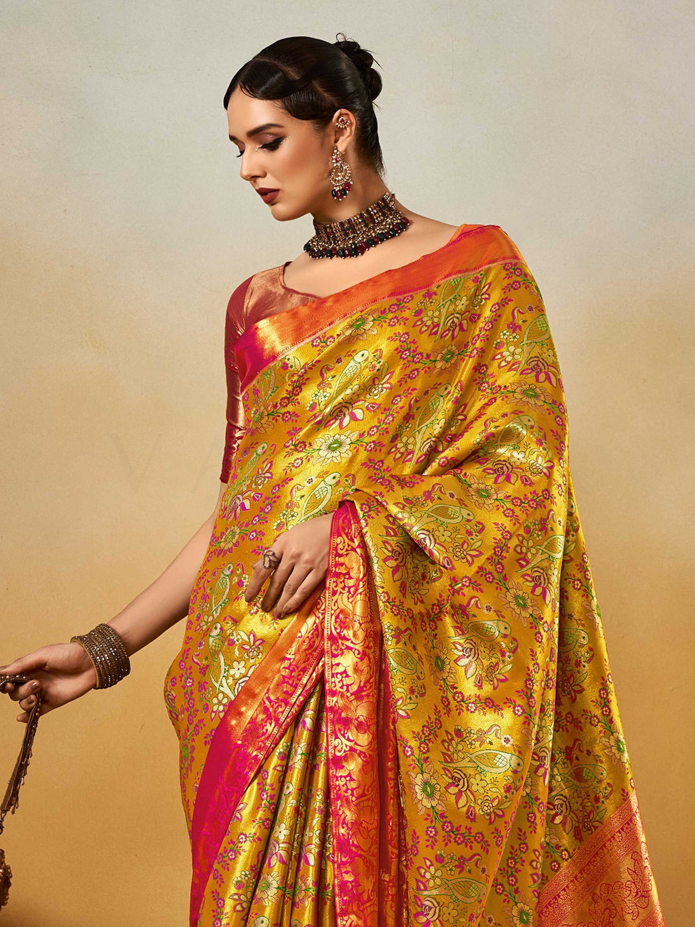 Yellow–Pink Banarasi satin silk saree with zari work and woven parrot motifs, styled for traditional Indian wedding rituals with luxury finish. Yellow–Pink Banarasi satin silk saree with zari work and woven parrot motifs, styled for traditional Indian wedding rituals with luxury finish..