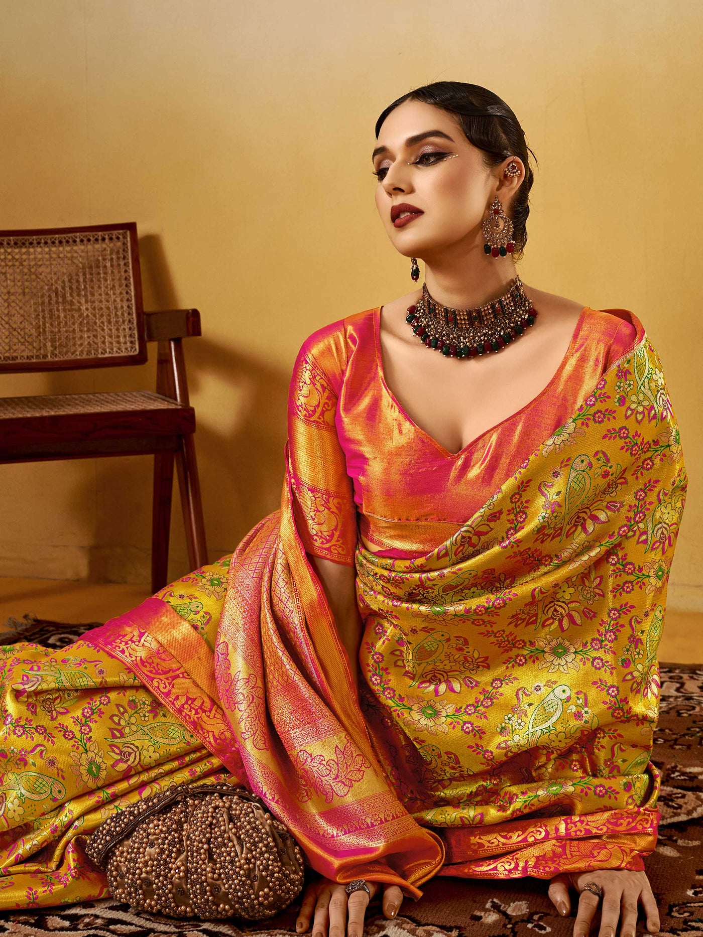 Yellow–Pink Banarasi satin silk saree with zari work and woven parrot motifs, styled for traditional Indian wedding rituals with luxury finish.
