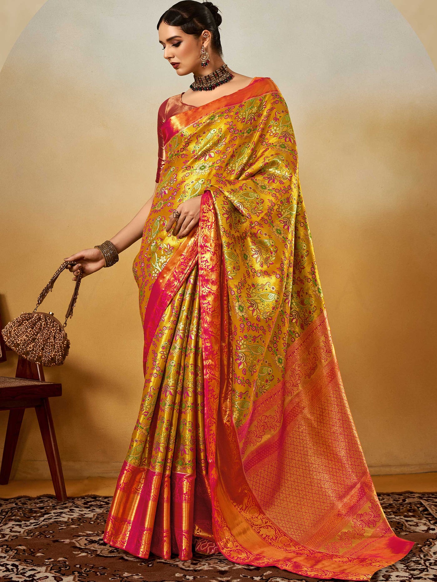 Yellow–Pink Banarasi satin silk saree with zari work and woven parrot motifs, styled for traditional Indian wedding rituals with luxury finish. Yellow–Pink Banarasi satin silk saree with zari work and woven parrot motifs, styled for traditional Indian wedding rituals with luxury finish..