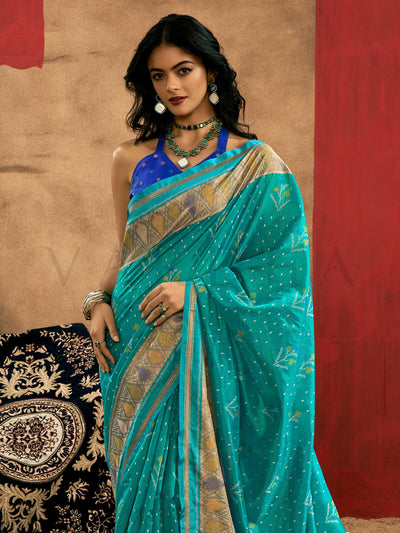 Teal Blue–Royal Blue Banarasi silk saree with Patola-inspired design and rich zari border, styled for wedding glamour and traditional elegance. Teal Blue–Royal Blue Banarasi silk saree with Patola-inspired design and rich zari border, styled for wedding glamour and traditional elegance..