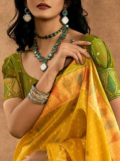 Sunflower Yellow–Leaf Green Banarasi silk saree with Patola-inspired design and rich zari border, styled for wedding glamour and traditional elegance. Sunflower Yellow–Leaf Green Banarasi silk saree with Patola-inspired design and rich zari border, styled for wedding glamour and traditional elegance..