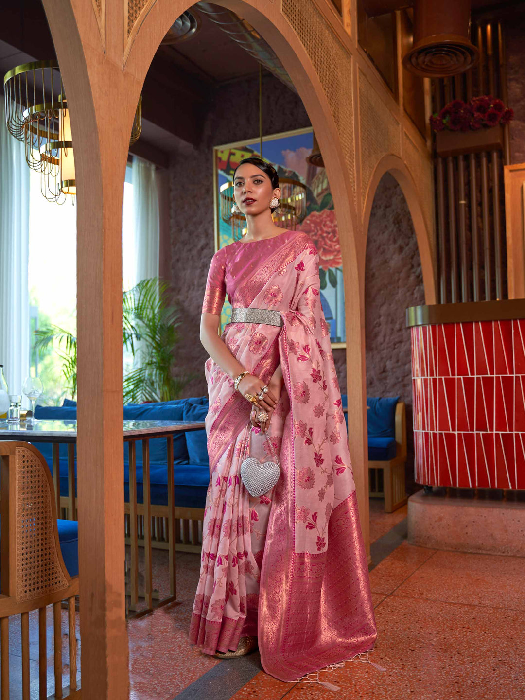 Baby Pink Shimmer Organza Saree with Copper Zari Weaving and Contrast Border, featuring an Exquisite Floral Jangla Design—a perfect blend of Traditional Craftsmanship and Modern Elegance for Festive Occasions. 
