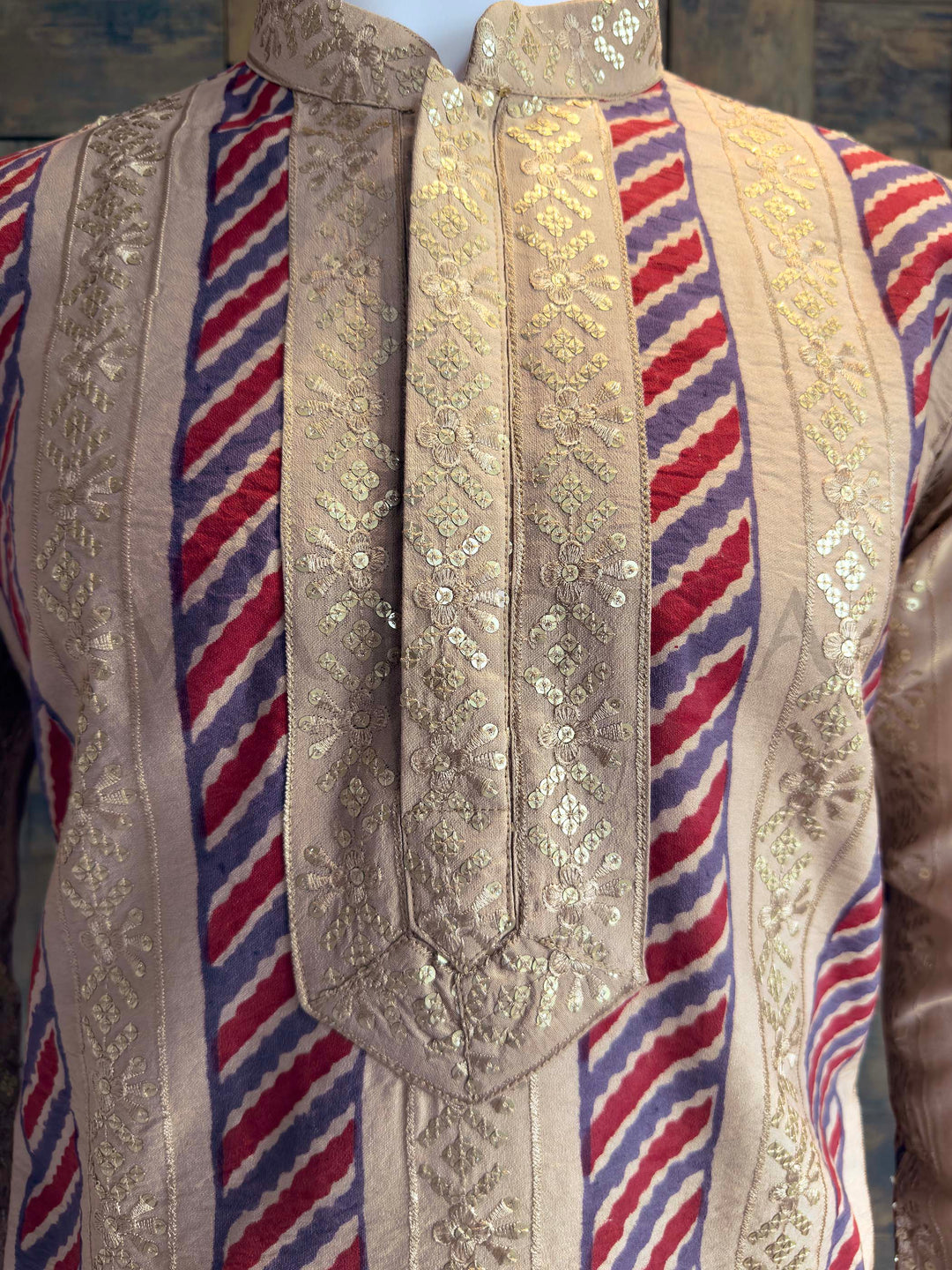 Detail of Heavy Gold Sequin Embroidery on Collar and Placket of Designer Kurta. Close-up of a decorative garment with intricate patterns and colors.