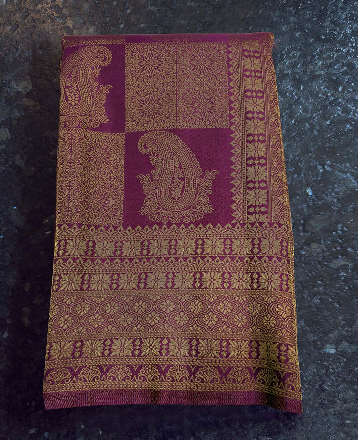 Decorative purple and gold fabric on a dark surface Texture shot showing the glossy satin finish of the soft silk fabric.