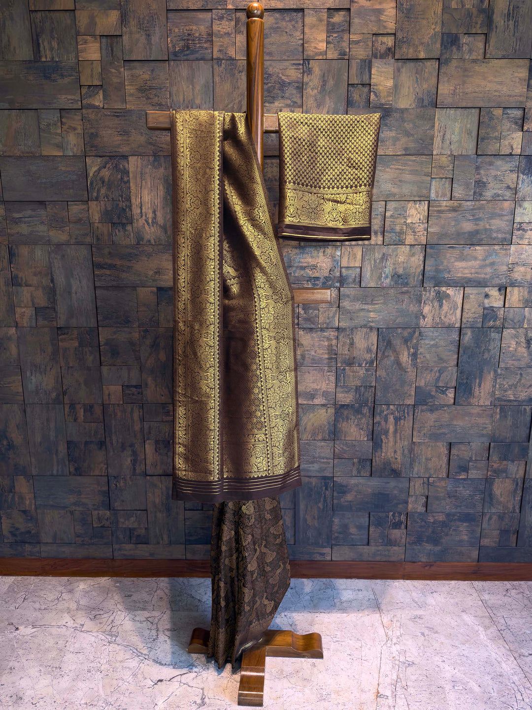 Traditional saree with a gold border on a wooden stand against a textured wall. Side-angle drape of Black Banarasi-inspired saree showcasing rich zari pallu and intricate weave