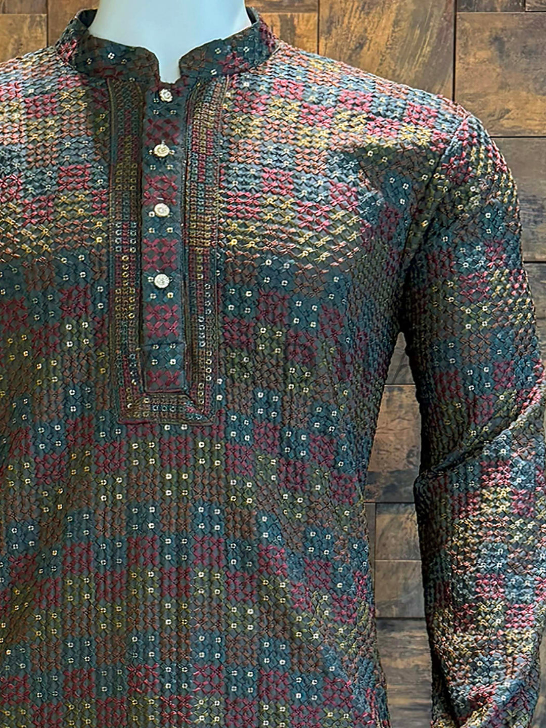 Close-up of embroidered placket kurta with ornate metallic buttons and mandarin collar. Ethnic wear men’s kurta in dark multicolor tones with woven embroidery accents.