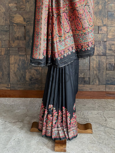 Graceful black raw silk saree with intricate Pashmina weave and embossed thread work, ideal for special celebrations
