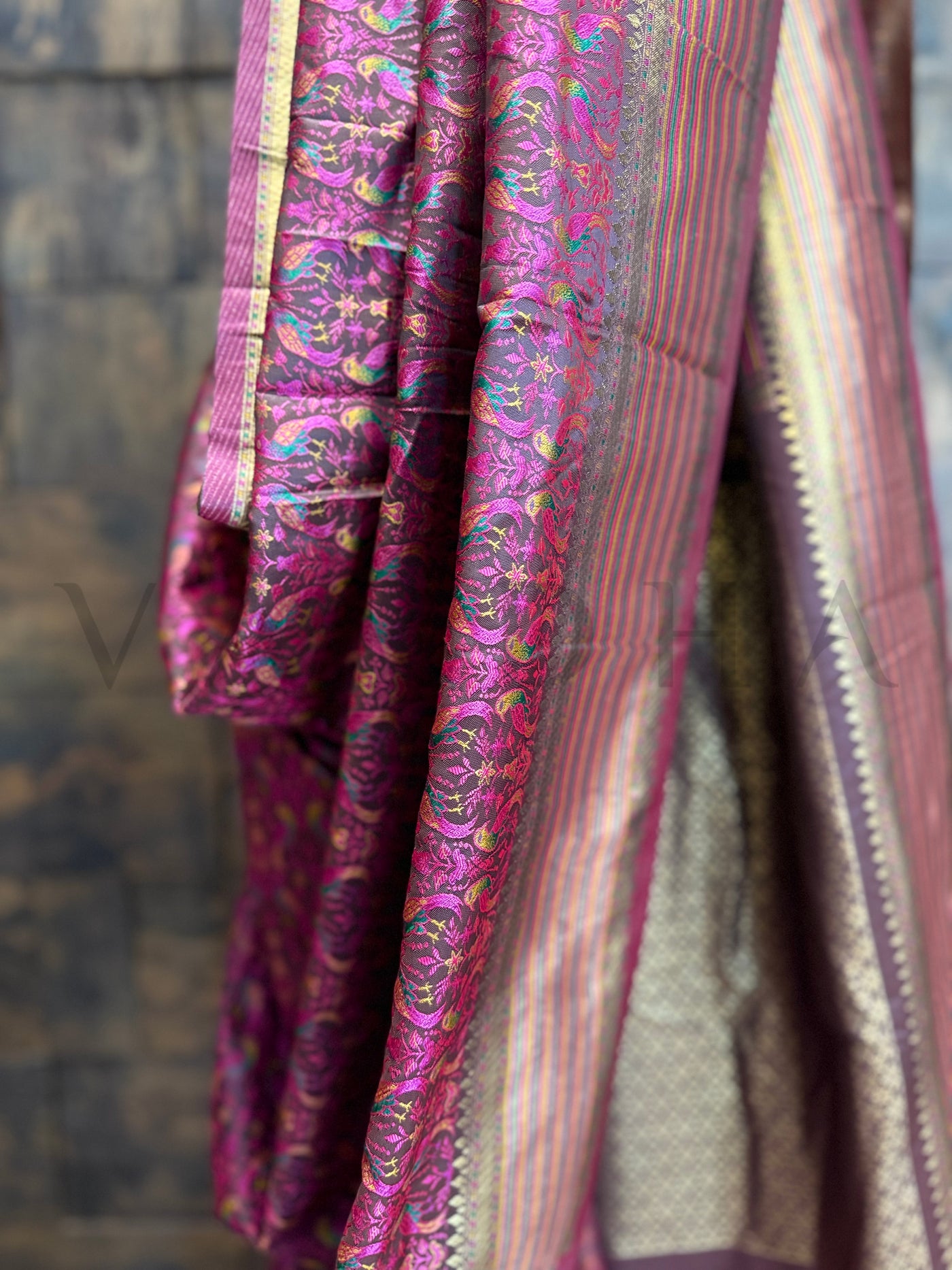 Detailed view of parrot motif thread weave on black satin silk saree with traditional zari finish and vibrant embroidery work