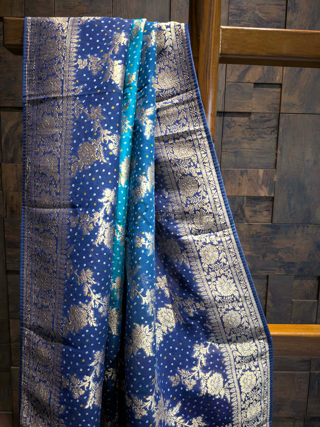 Blue fabric with silver patterns draped over a wooden surface