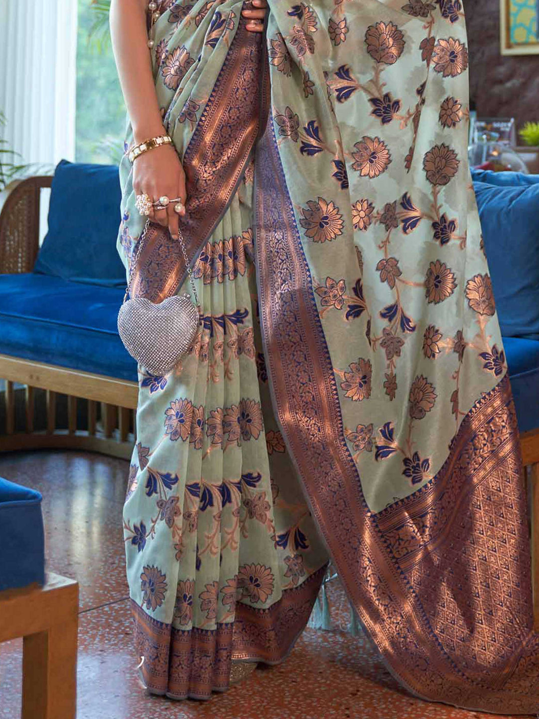 Luxurious Blue Shimmer Organza Saree enriched with Copper Zari Weaving and a Contrast Border, ensuring a Graceful Drape—suitable for Traditional Functions and Modern Festivities. 
