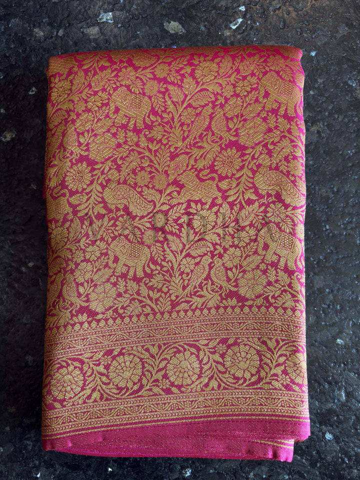 Folded fabric with floral pattern on a dark surface Unstitched pink blouse piece with zari border paired with saree