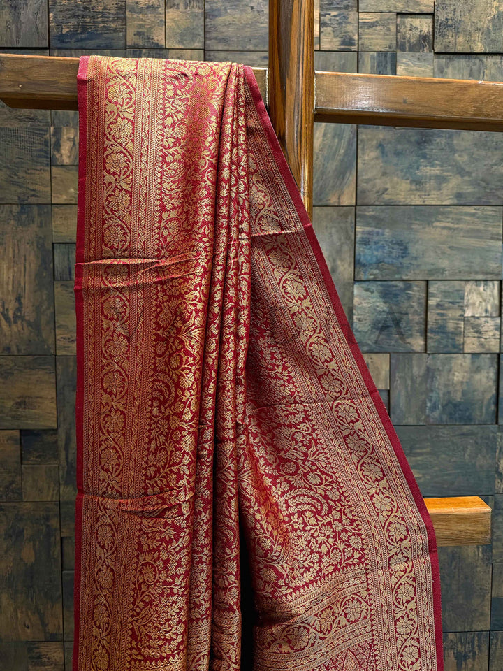 Close-up of intricate golden zari weaving with paisley and leaf motifs on the wine maroon Mysore silk saree Side angle showing the woven double border and sheen of the viscose Mysore silk saree