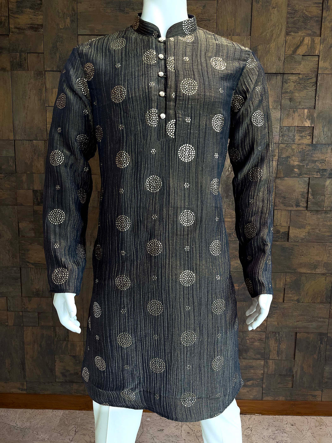 Stylish Party Wear Men's Kurta with Shimmering Gold Motifs and Straight Fit. Dark gray kurta with intricate patterns on a mannequin against a wooden paneled wall.