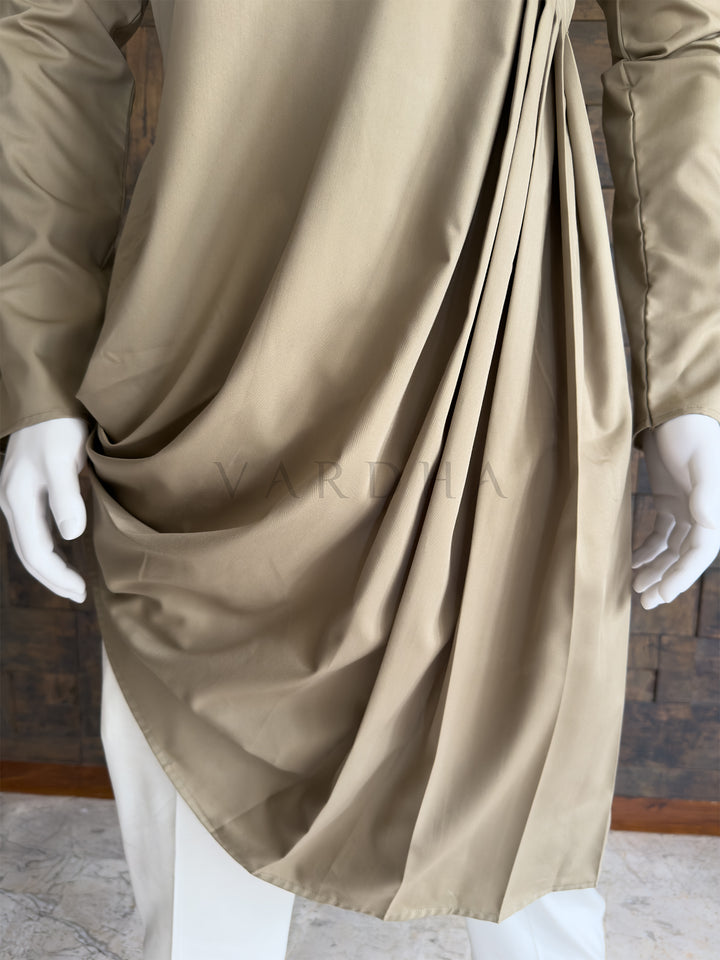 Beige fabric draped over a mannequin with white gloves, on a neutral background. Close-up of the full sleeve and the voluminous side folds of the asymmetric drape on the chiku beige cotton kurta, offering a contemporary twist on traditional wear.
