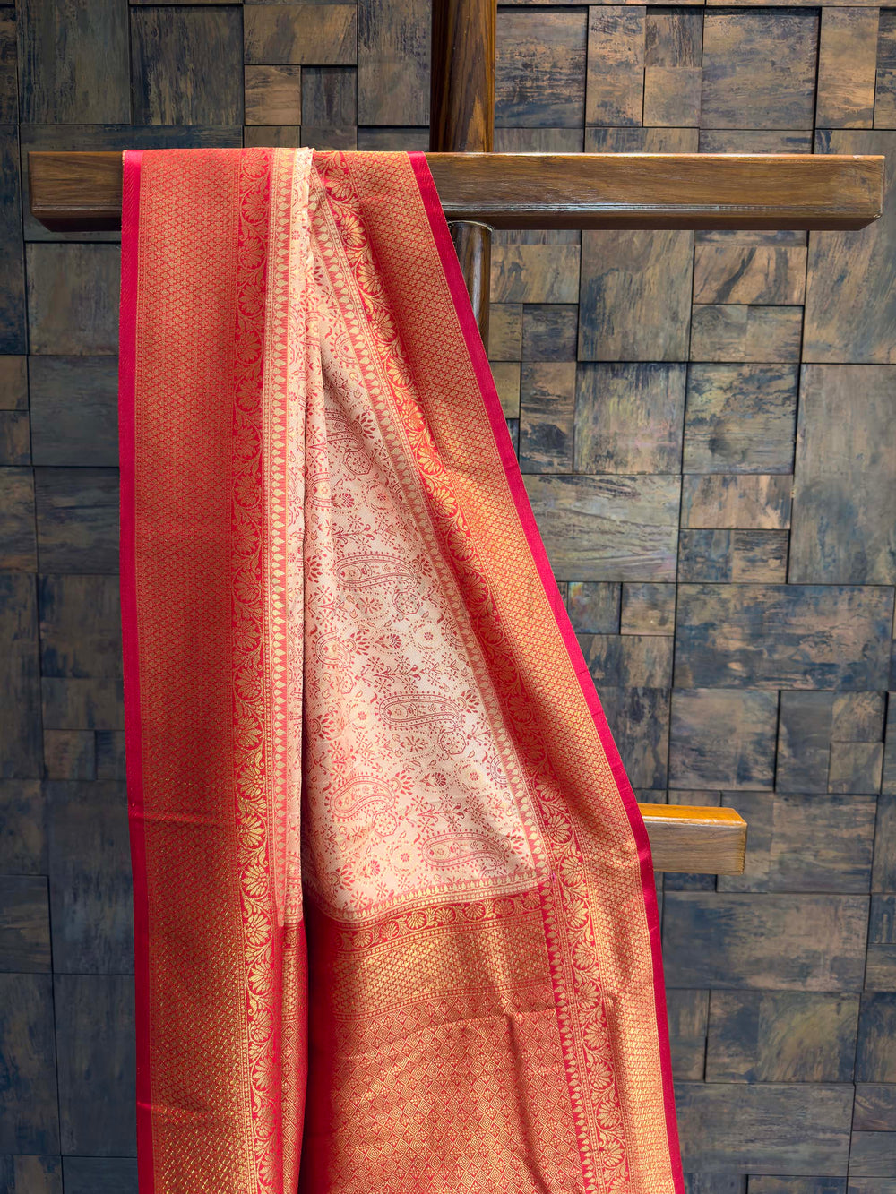 Close-up of the cream satin body showing red woven paisley motifs.
