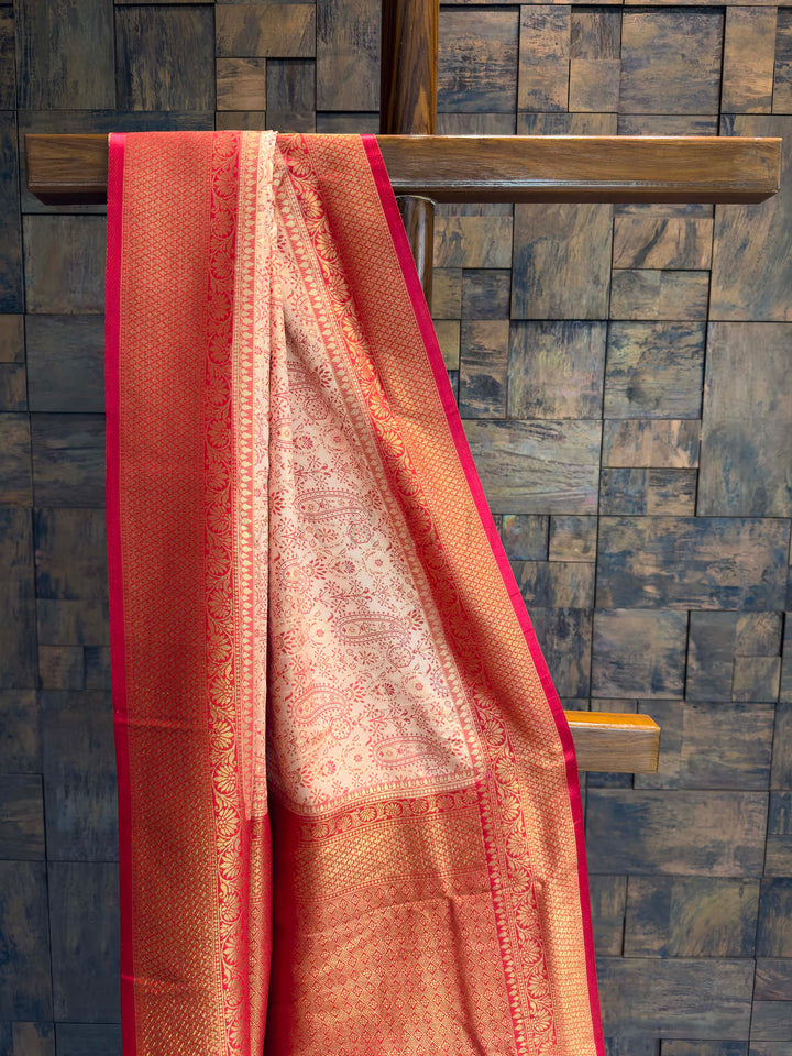 Close-up of the cream satin body showing red woven paisley motifs.
