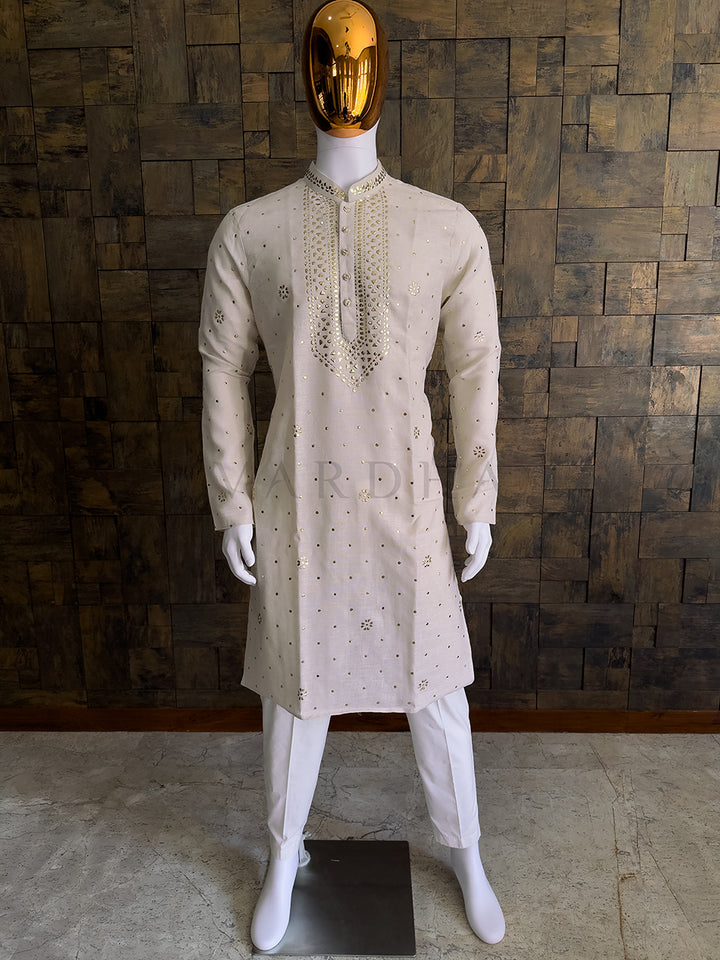 Mannequin wearing a beige embroidered kurta with white pants against a wooden paneled wall. Elegant cream khadi cotton men&