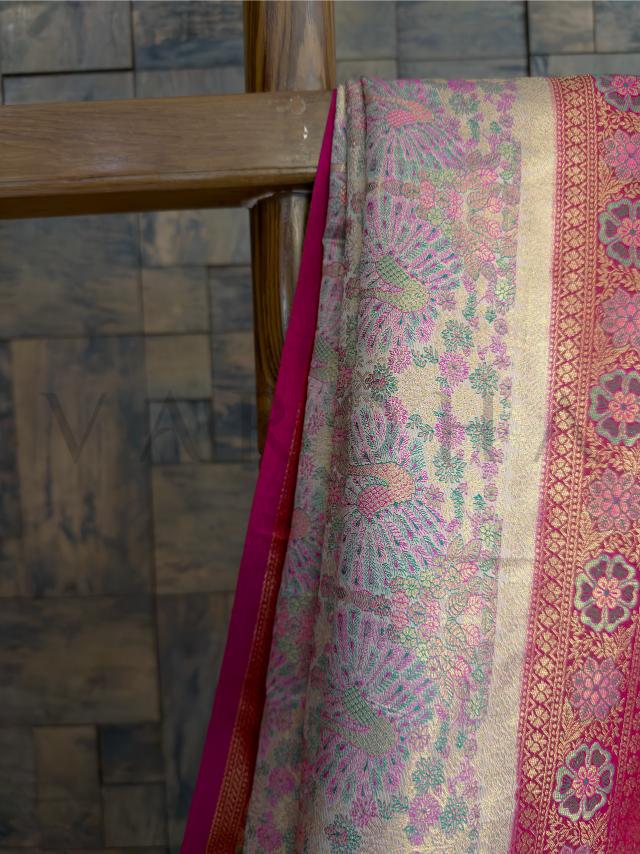 Cream Pink Kalamkari Art Silk Saree featuring woven zari border, floral peacock motifs, and elegant pink pallu. Ideal for weddings, festivities, and traditional celebrations.
