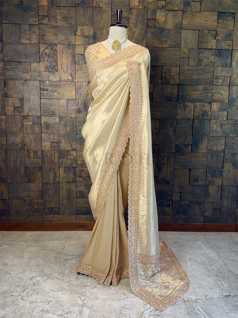 Cream saree with intricate patterns on a mannequin against a wooden paneled wall. Full View Cream Viscose Saree with Pearl Handwork for Receptions