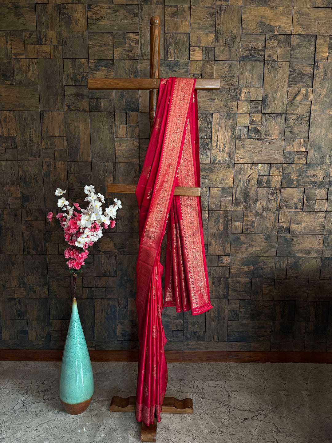 Crimson red satin saree with light gold zari temple border and floral pallu. Beautifully draped Crimson Red Satin Saree showcasing the soft fall of the fabric and the glimmer of the Light Gold Zari floral patterns by House of Vardha. We offer Ready to wear, Pre drape service, Saree Add on, Custom Stitched Blouse, Fall and Edging, Gift Packaging at Complimentary Price!