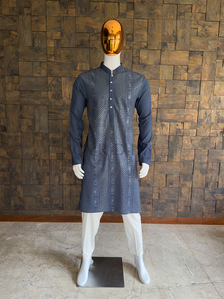 Mannequin wearing a grey patterned kurta against a wooden paneled wall. Front view of a man wearing a House of Vardha dark grey viscose kurta featuring diagonal sequin embroidery and vertical floral motifs. Perfect men's ethnic wear for evening weddings, receptions, and festive celebrations.