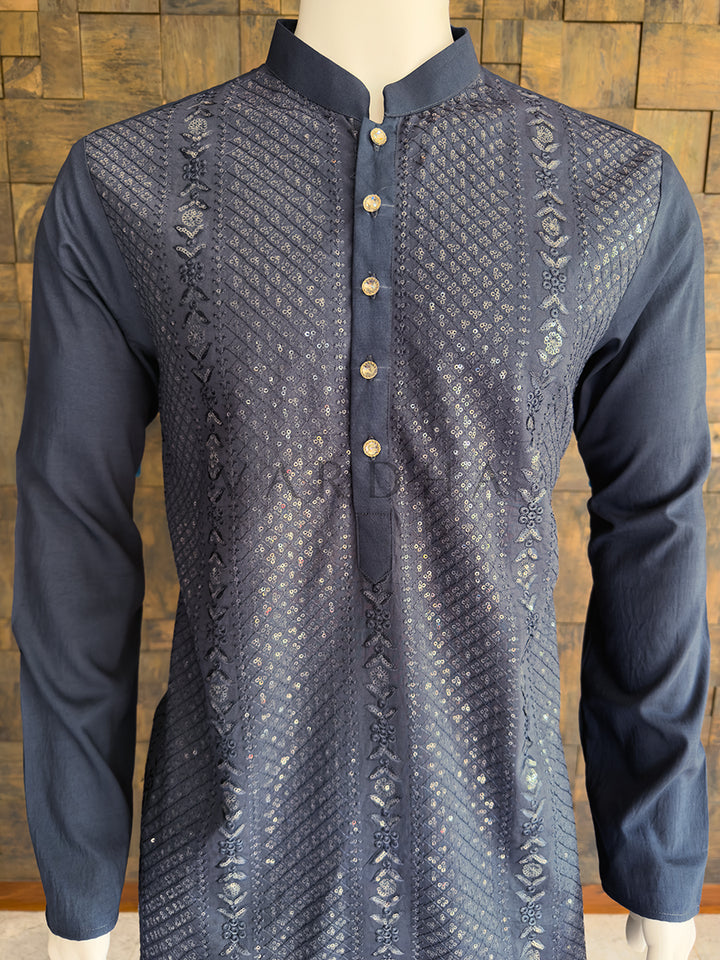 Grey kurta with intricate patterns on a wooden background. Detailed chest view highlighting the premium rhinestone buttons and the rich shimmering sequin embroidery on the luxurious dark grey viscose designer kurta for men.