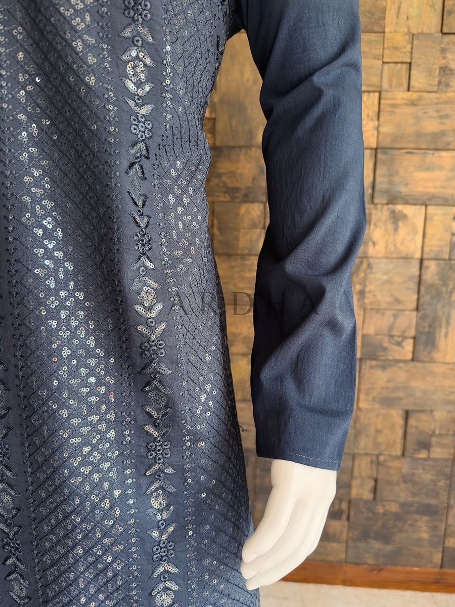 Mannequin wearing a dark grey embroidered garment against a wooden paneled wall. Close-up of the solid dark grey full sleeve alongside the heavily embroidered bodice, highlighting the detailed vertical floral threadwork and sequin embellishments for sangeet and wedding wear.