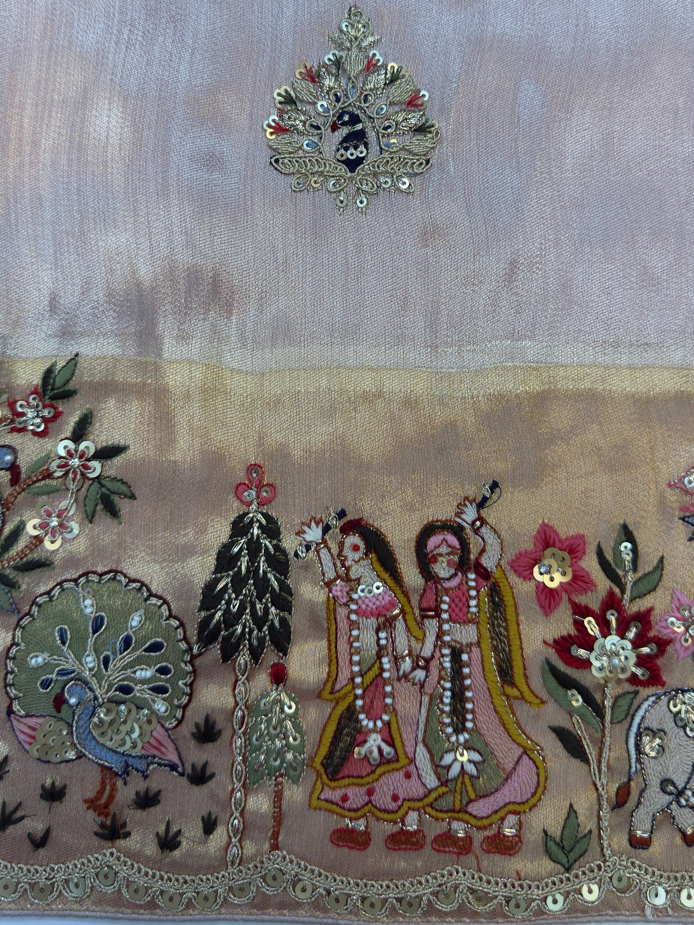 Delicate floral butta detailing scattered across soft tissue silk body—lightweight and festive with emotional symbolism.
