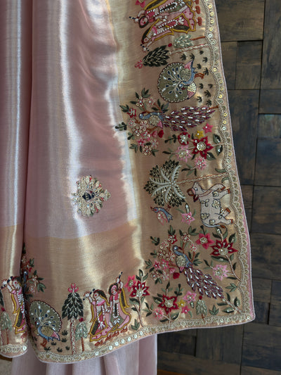 Decorative fabric with intricate embroidery and embellishments on a wooden surface