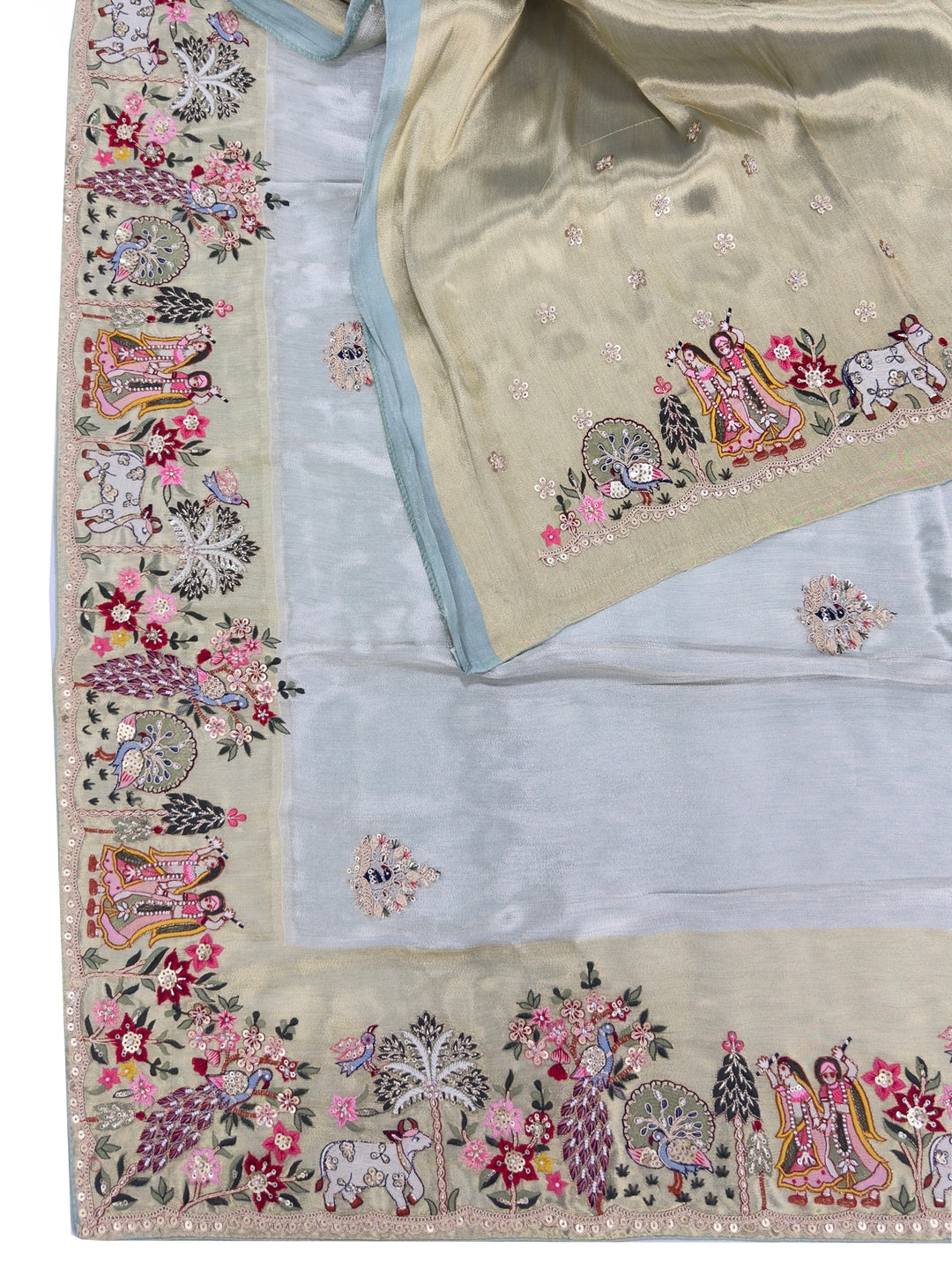 Full saree view with Radha Krishna hand embroidery and floral vines across light green tissue silk, perfect for temple or haldi functions.
