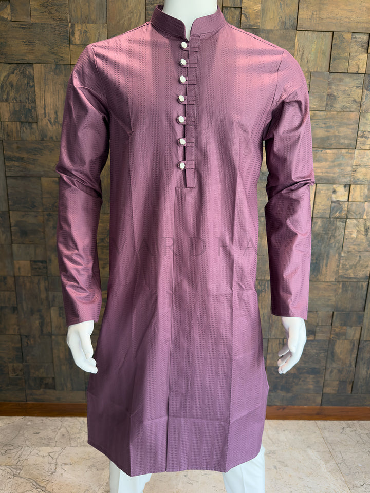 Mauve kurta on a mannequin against a wooden paneled wall. Knee-length Dusty Mauve Pink kurta featuring a formal Mandarin collar, full sleeves, and striking silver mirror-finish buttons for a bold contrast.