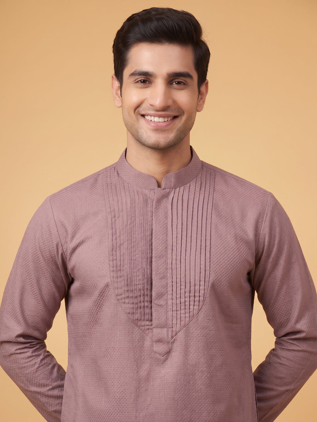 Close-up front view of a man wearing a dusty taupe cotton short kurta featuring a detailed structured pintuck yoke.