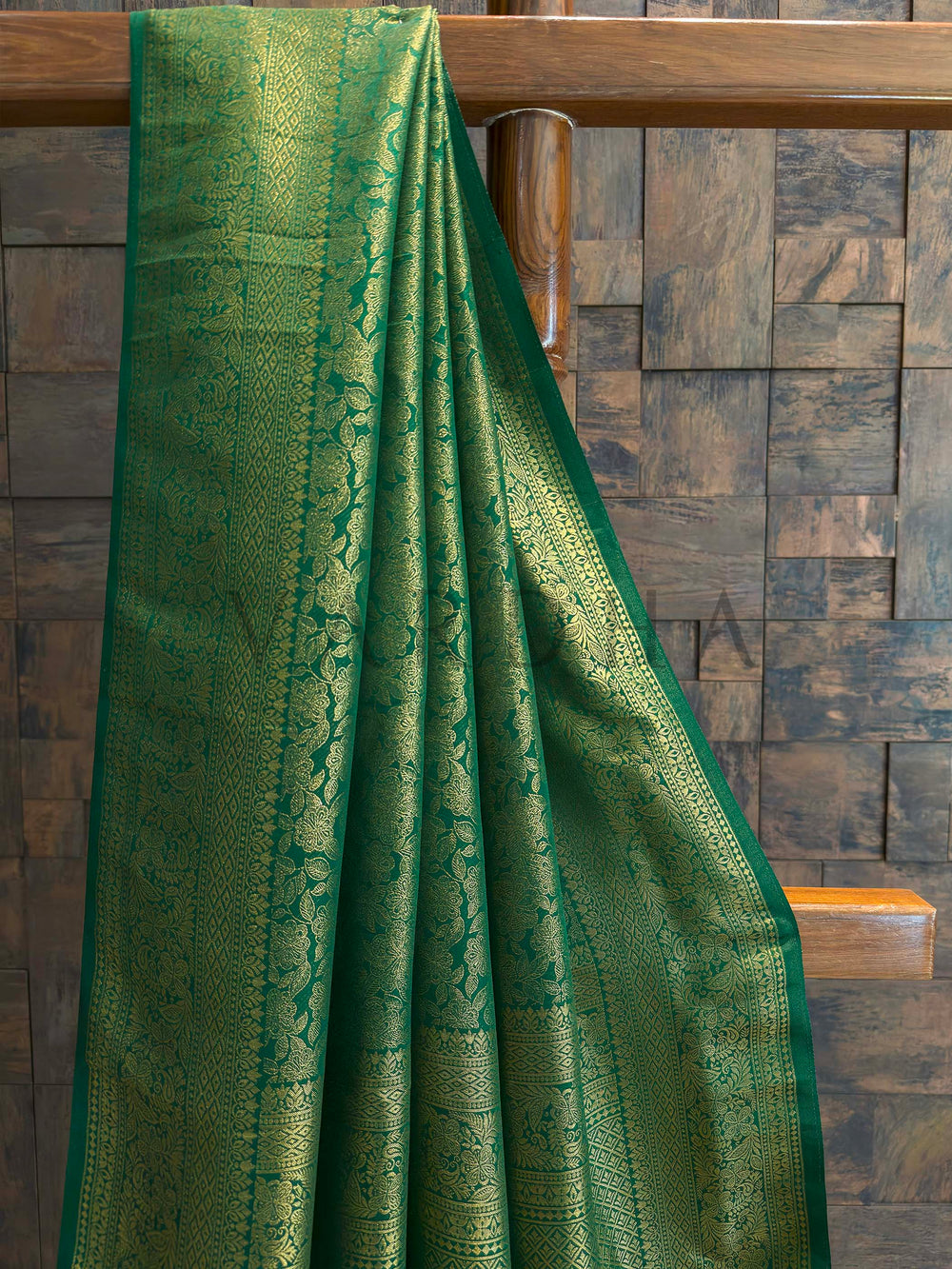 Close-up of emerald green saree body featuring dense gold zari floral jaal with vine motifs and slim contrast selvedge, luxurious Kanjivaram art silk texture ideal for festive occasions.