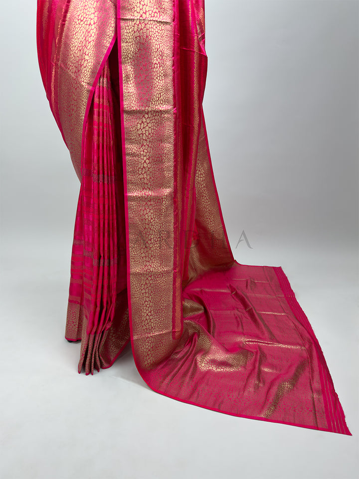 Pink saree with gold patterns on a white background Elegant pleats and lower drape of a Rani Pink Tanchoi Silk Saree, highlighting the rich gold-woven border and graceful fall of the fabric.

