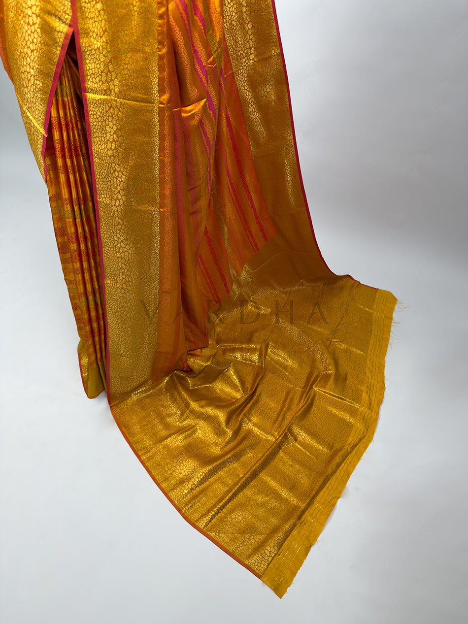 A high-angle shot showcasing the lower section and the magnificent spread of the Yellow Tanchoi Silk Saree&