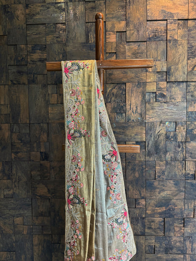 Gold wedding saree in Kanjivaram tissue silk with multi-color embroidered motifs and embellished edges.