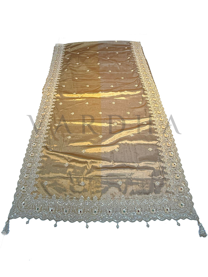 Off White Kanjivaram Tissue Saree with embroidered motifs and floral zari highlights displayed on a wooden stand.
