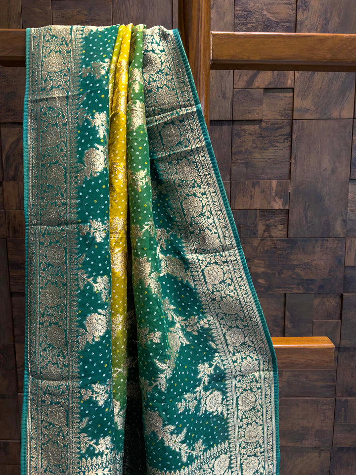Green patterned fabric draped over a wooden chair against a wooden paneled wall.
