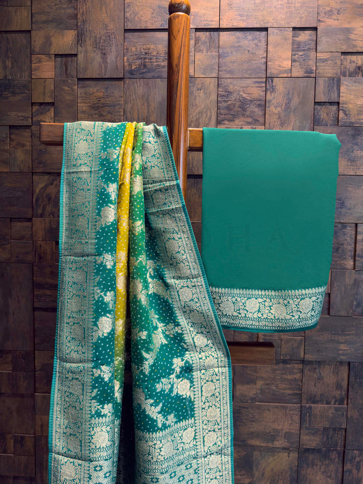 Two green patterned cloths draped over a wooden rod against a wooden paneled wall.