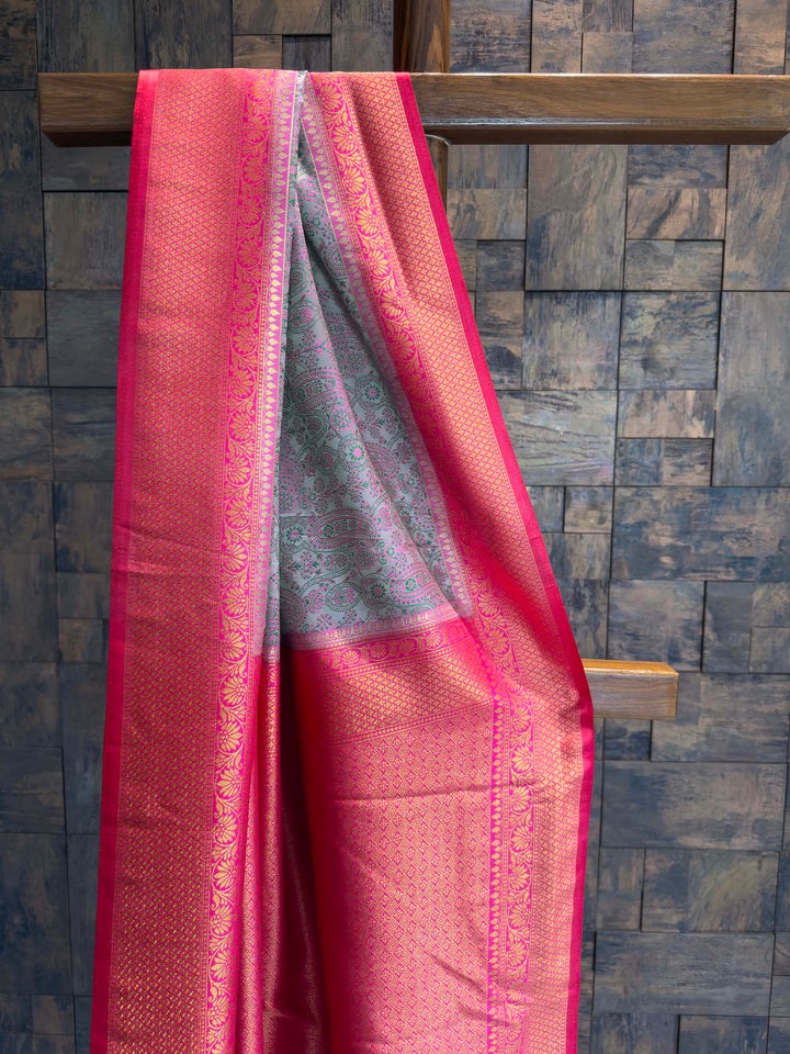 Close-up of the grey satin body showing green and pink woven paisley motifs.