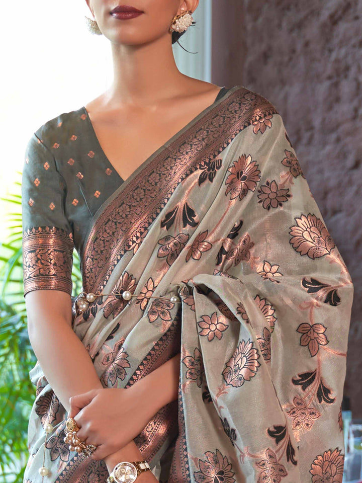 Handcrafted Grey Organza Saree with Copper Zari Embellishments and a Contrast Woven Border, showcasing Traditional Phool Bel Motifs—a statement piece for Cultural Celebrations and Special Events. 
