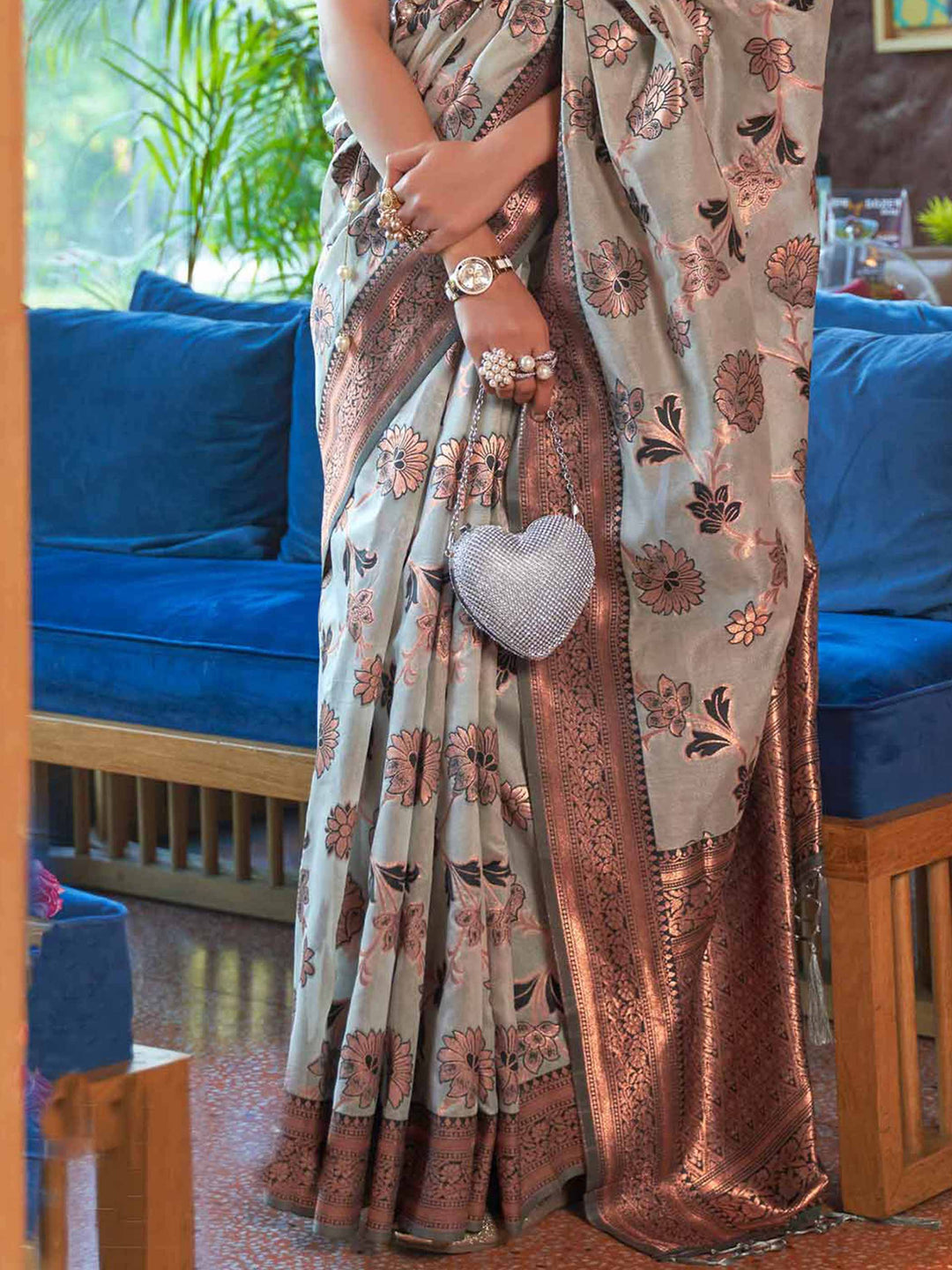 Luxurious Grey Shimmer Organza Saree enriched with Copper Zari Weaving and a Contrast Border, ensuring a Graceful Drape—suitable for Traditional Functions and Modern Festivities. 
