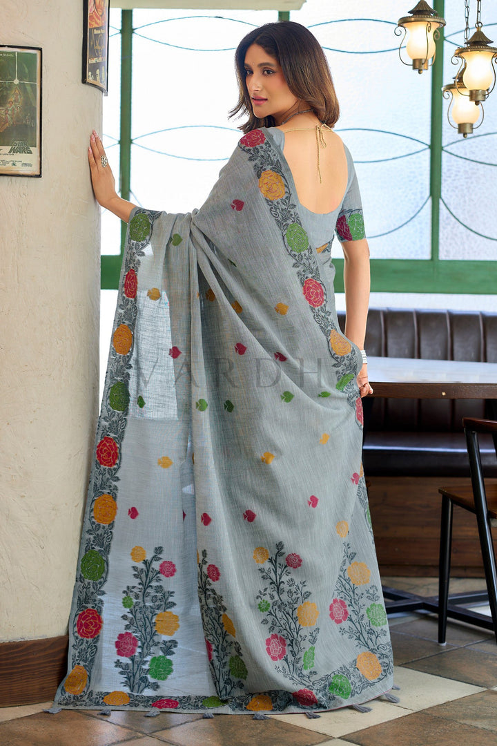 Back view of the grey linen jacquard saree displaying the stunning oversized woven floral vines and matching grey fancy tassels on the designer pallu.
