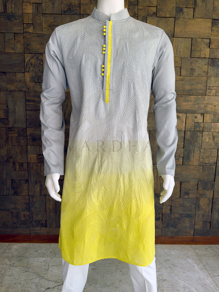 Gray and yellow kurta on a mannequin against a wooden paneled wall. Close-up of the grey and lemon yellow ombre men&