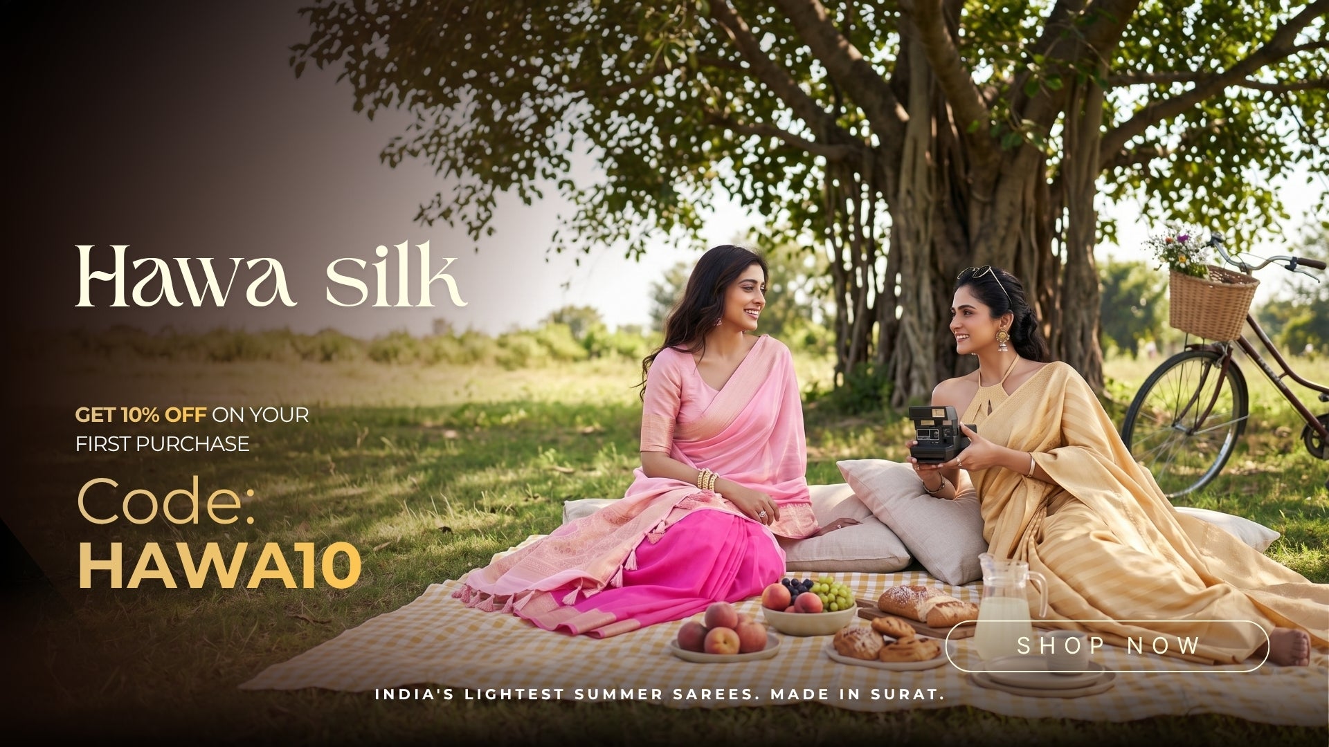 Two women in traditional silk sarees sitting under a tree with a picnic, promoting Hawa Silk. Shop this Feathersoft Lightweight sarees from House of Vardha.